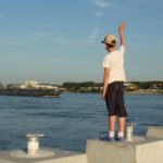Boy waving goodbye to a ship