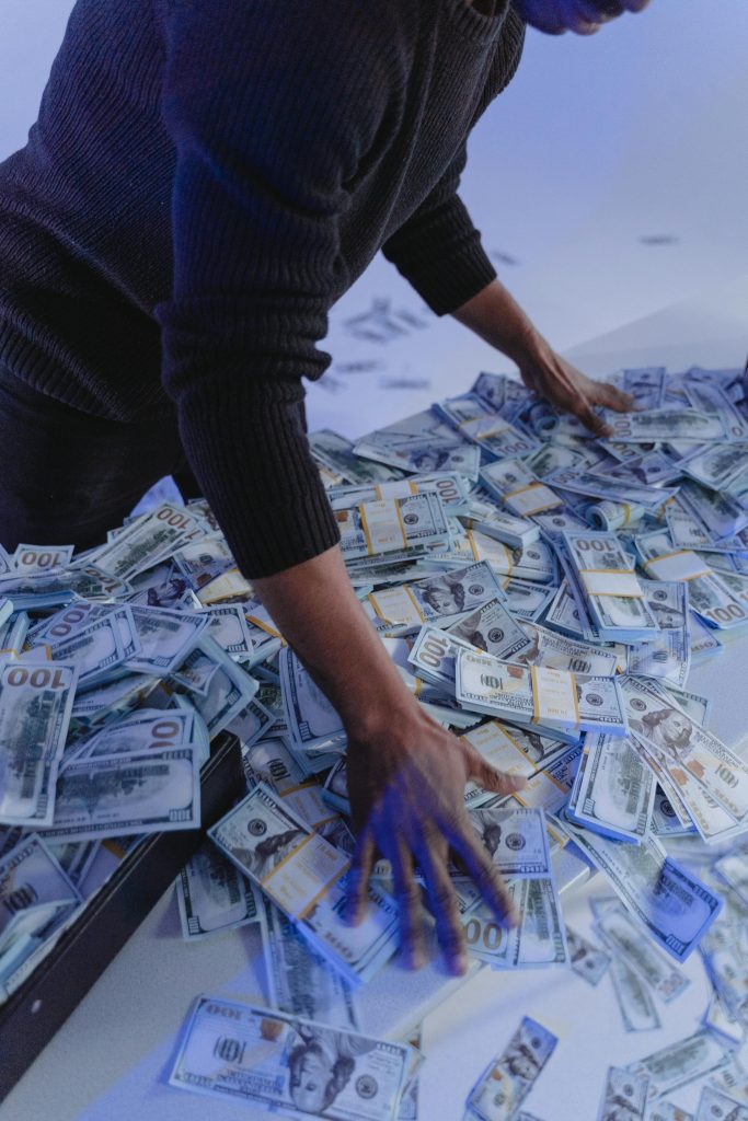 Man standing over pile of cash