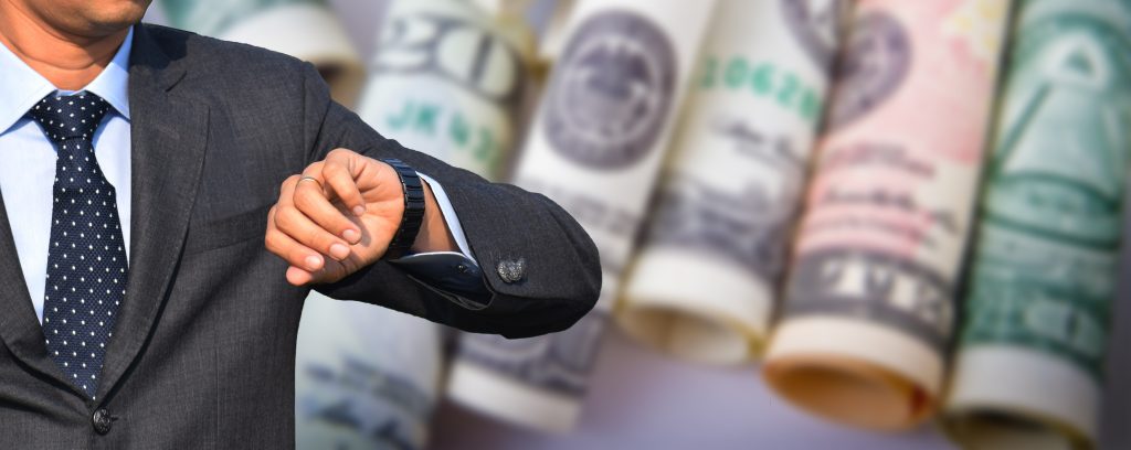 Man looking at watch with cash in background